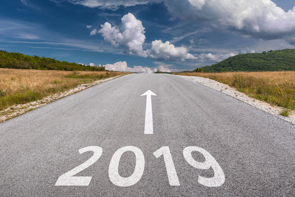 View down a road with 2019 painted on the road in the foreground